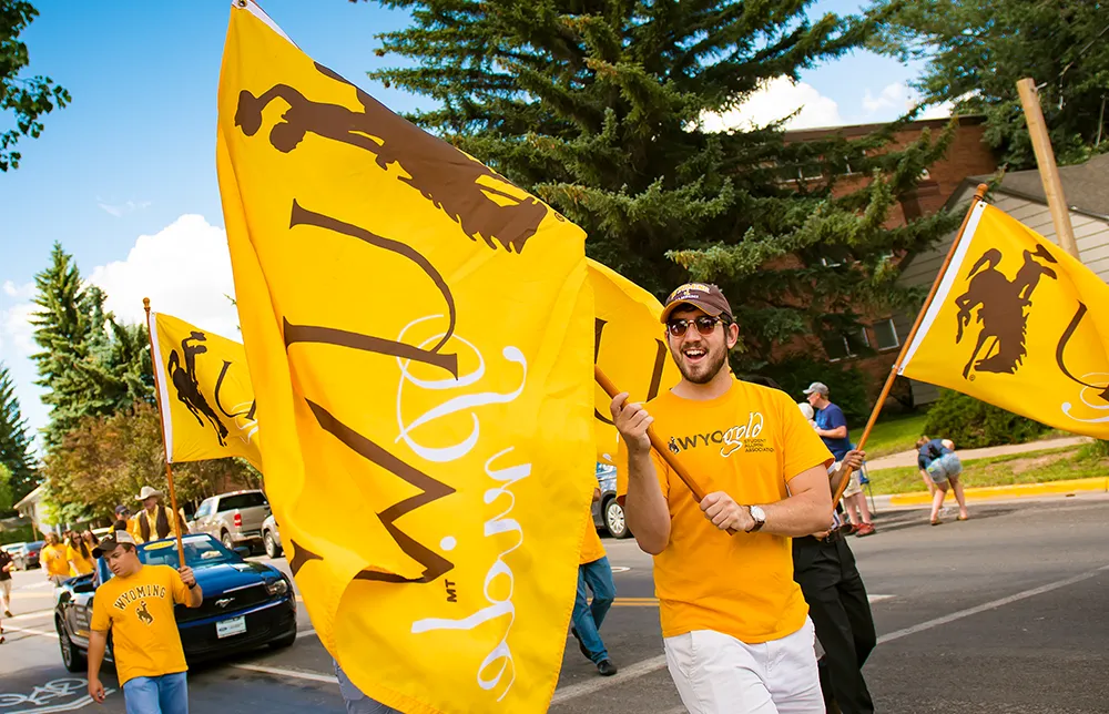 Student holding UW flag in community